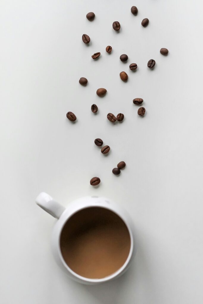 Secangkir kopi hitam dengan biji kopi sangrai